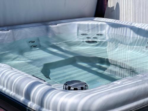 a bath tub with a dog sitting in it at Luxury Villa with hot tub! Walk to Beach & Bars in Long Beach