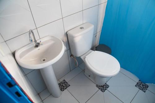 a bathroom with a white toilet and a sink at Calango Hostel in Ibicoara
