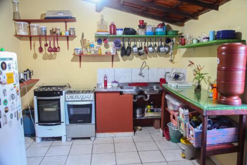 a kitchen with a stove and a sink at Calango Hostel in Ibicoara