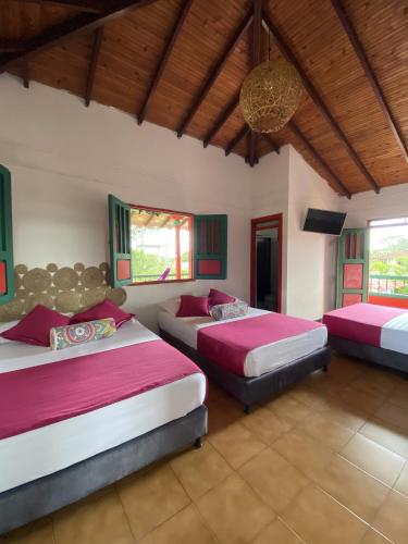 a bedroom with two beds and a chandelier at Casa Abba Hotel in La Tebaida