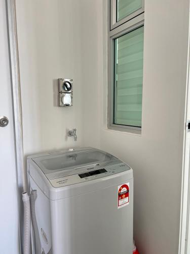 a washing machine in a bathroom with a window at Rayyan Condominium @ Metrocity Square in Kuching