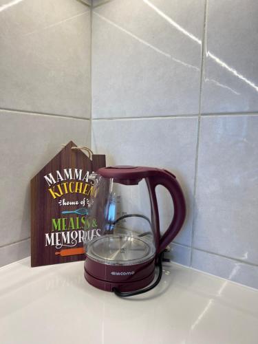 a tea kettle on a counter next to a book at Rayyan Condominium @ Metrocity Square in Kuching