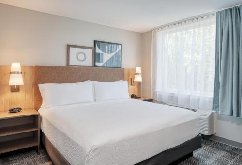 um quarto com uma cama branca e uma janela em Staybridge Suites Federal Way - Seattle South , an IHG Hotel em Federal Way