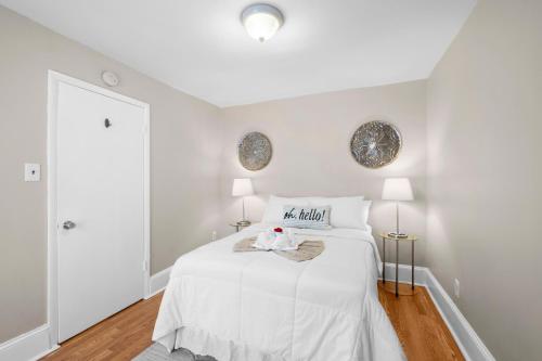 a white bedroom with a white bed and two lamps at 1 Bdrm Modern Posh Upenndrexel Univ in Philadelphia