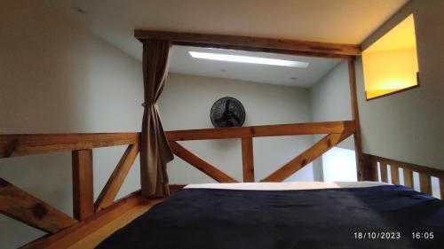 1 dormitorio con 1 cama con marco de madera en Loft Rústico - Curitiba, en Curitiba