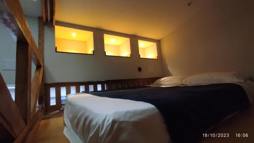 1 dormitorio con 1 cama grande y 2 ventanas en Loft Rústico - Curitiba, en Curitiba