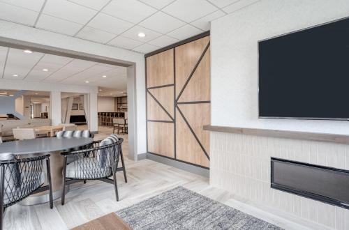 a dining room with a table and a tv on a wall at Staybridge Suites Federal Way - Seattle South by IHG in Federal Way