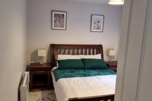 a bedroom with a bed with two green pillows at Teachín na Siúire 
