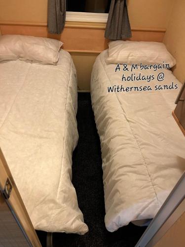 two beds sitting next to each other in a room at AM bargain holidays at Withernsea sands in Withernsea