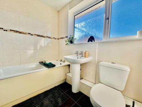 baño con lavabo y aseo y ventana en Canvey Island Bliss By Artisan Stays I Free Parking I Sleeps 5 I Relocation or Business, en Canvey Island