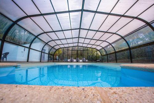 una piscina coperta con soffitto in vetro di Domaine de Lann Kerhuerh a La Chapelle-Neuve