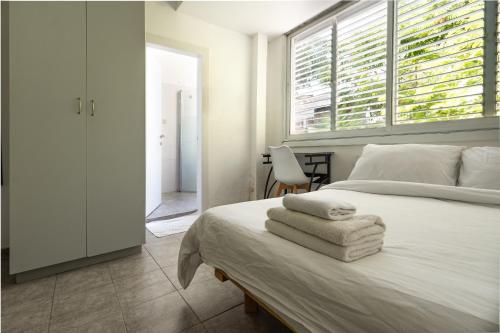 - une chambre avec un lit et des serviettes dans l'établissement Studio 91 By IsrApart, à Ramat Gan