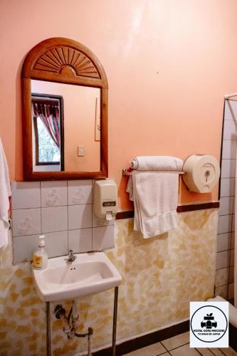 a bathroom with a sink and a mirror at Hostal Doña Mercedes in Juayúa