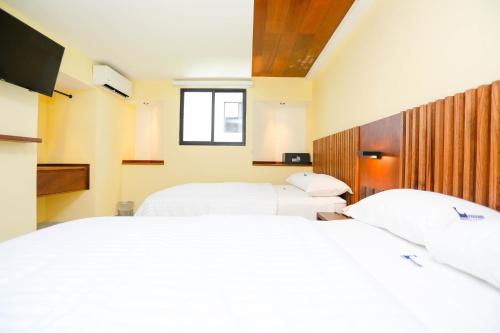 een slaapkamer met 2 bedden en een raam bij Hotel Parador in Cancun