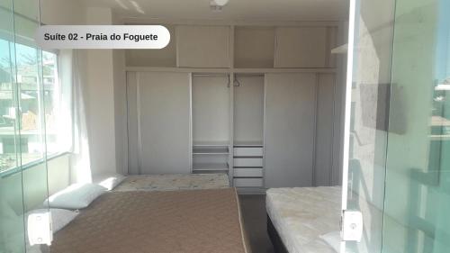Habitación pequeña con cama y ventana en Praia do Foguete - Aluguel Econômico en Cabo Frío
