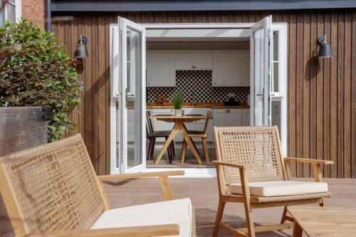 een patio met stoelen en een tafel en een keuken bij Flat 1 Highgate, Walford Road, Ross on Wye in Wilton