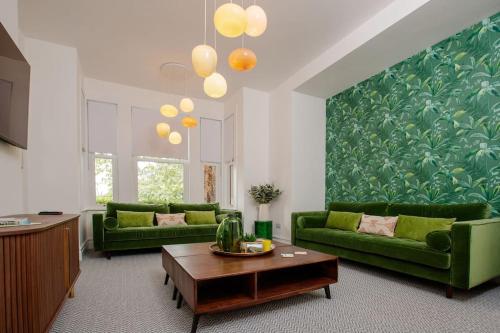 a living room with green couches and a coffee table at Flat 1 Highgate, Walford Road, Ross on Wye in Wilton