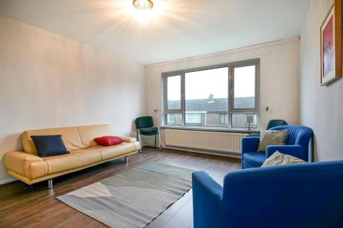 ein Wohnzimmer mit einem Sofa, 2 Stühlen und einem Fenster in der Unterkunft 2 Bed Apartment near Belfast & Ferry in Belfast