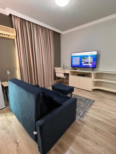 een woonkamer met een bank en een flatscreen-tv bij HOTEL PERDIZES - FLAT Executivo - 1204 in Sao Paulo