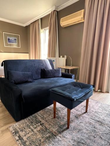 a blue couch and a stool in a living room at HOTEL PERDIZES - FLAT Executivo - 1204 in São Paulo