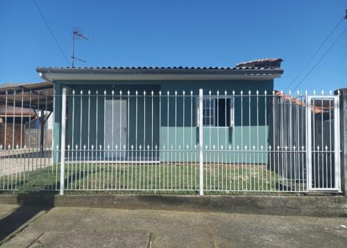 a white fence in front of a house at Hosthê compartilhados in Canoas