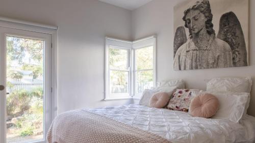een slaapkamer met een bed met een standbeeld aan de muur bij Relax by the Sea in Queenscliff