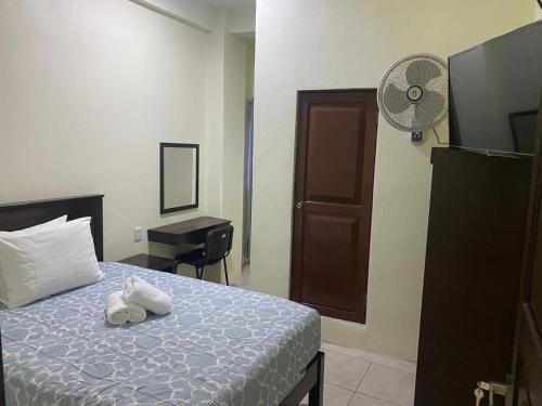 a bedroom with a bed with a fan and a desk at Hotel Magnolia Tek Ulte´ in Comitán