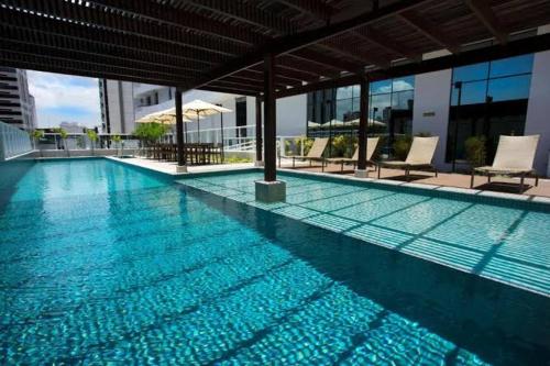 una gran piscina con sillas en un edificio en Apartamento Mondial Salvador, en Salvador