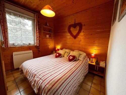 a bedroom with a bed in a wooden room at Appartement avec Terrasse & Piscine Privée, Gérardmer - FR-1-589-56 in Gérardmer