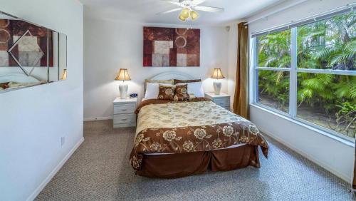 ein Schlafzimmer mit einem Bett und einem großen Fenster in der Unterkunft House Rainbow in Cape Coral