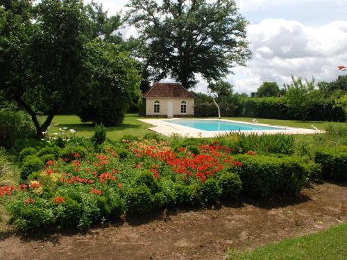 un jardin avec une maison et une piscine dans l'établissement Petite maison de campagne avec piscine chauffée, tennis et nombreuses activités pour tous! - FR-1-410-270, à Maresché