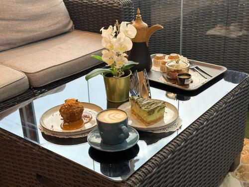 - une table basse avec des gâteaux et des desserts dans l'établissement فندق جارة الغيم للاجنحة الفندقية, à Fayfāʼ