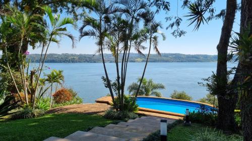 Una vista del agua desde un resort con piscina. en Cabaña Santa Ana, en Santa Ana