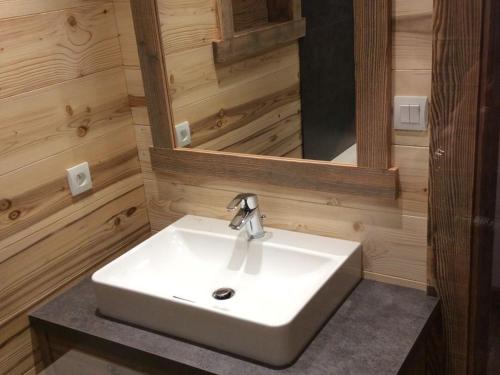 une salle de bain avec un lavabo blanc et un miroir dans l'établissement Chalet confortable, proche des pistes de ski, avec jardin, terrasses couvertes et Wi-Fi à La Bresse - FR-1-589-86, à La Bresse