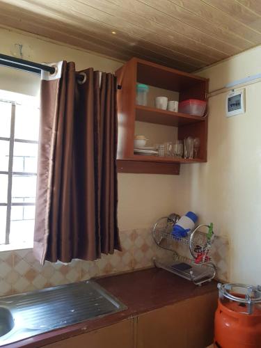 uma cozinha com um lavatório e uma janela num quarto em Hakuna matata Airbnb em Machakos