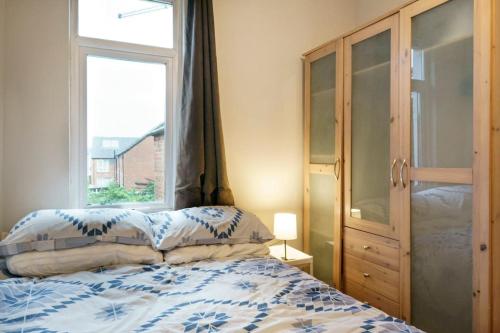 1 dormitorio con cama y ventana en House Close to City Centre and City Airport, en Belfast