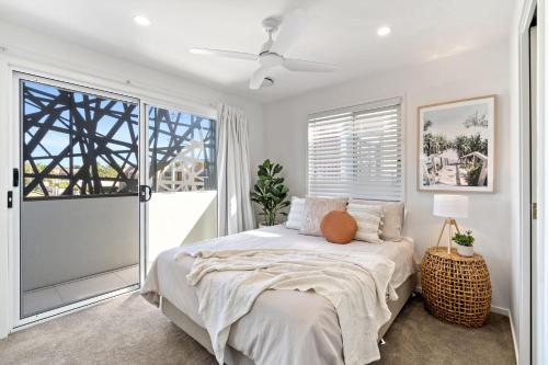 a white bedroom with a bed and a window at Casa Allura in Coolum Beach