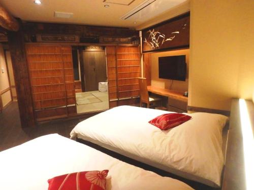 a bedroom with two beds and a desk and a television at 【都電屋205】两卧室套房/都电荒川线/近三ノ輪/一线直达秋叶原/上野/浅草 in Tokyo