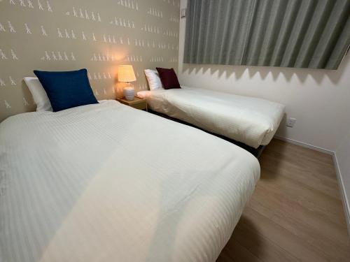 two twin beds in a room with at ベアーズステイ久米島ヴィラ in Kumejima