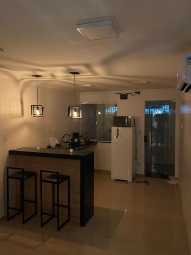 uma cozinha com um balcão e um frigorífico em RM hospedagem unidade Gamboa em Cabo Frio