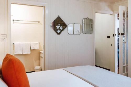 a white bedroom with a bed and a mirror at Tillrander - Scamander Retreat in Scamander