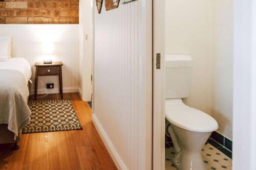 a small bathroom with a toilet and a bed at Tillrander - Scamander Retreat in Scamander