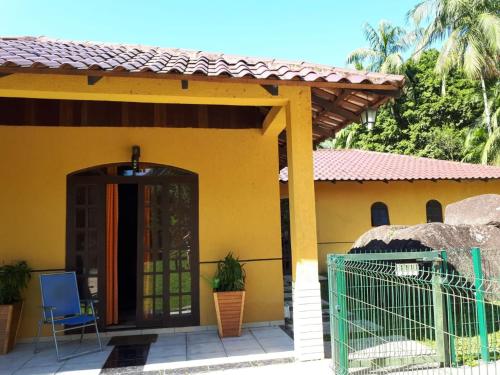 a yellow house with a gate in front of it at Chacara Salmo 27 in Antonina