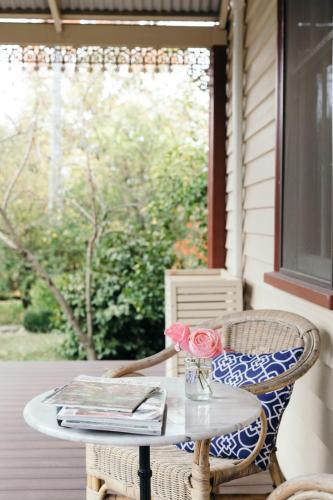 a table with a vase of flowers on a porch at Summerlands - Country Luxe in Alexandra