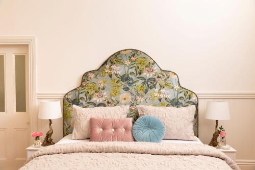 a bedroom with a large bed with a floral headboard at Summerlands - Country Luxe in Alexandra
