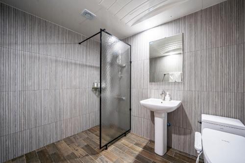 a bathroom with a shower and a sink and a toilet at Cherryblossom in Changwon