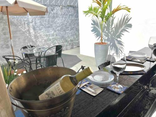 a bottle of wine in a bucket on a table at Acolhedora casa de 03 quartos in Passos