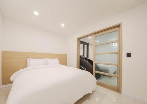 a white bed in a room with a window at Rium Hotel in Mokpo
