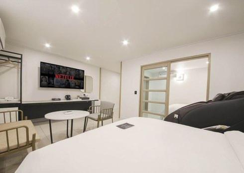 a room with a bed and a table and chairs at Rium Hotel in Mokpo