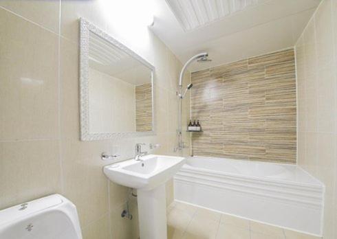 a white bathroom with a sink and a bath tub at Rium Hotel in Mokpo